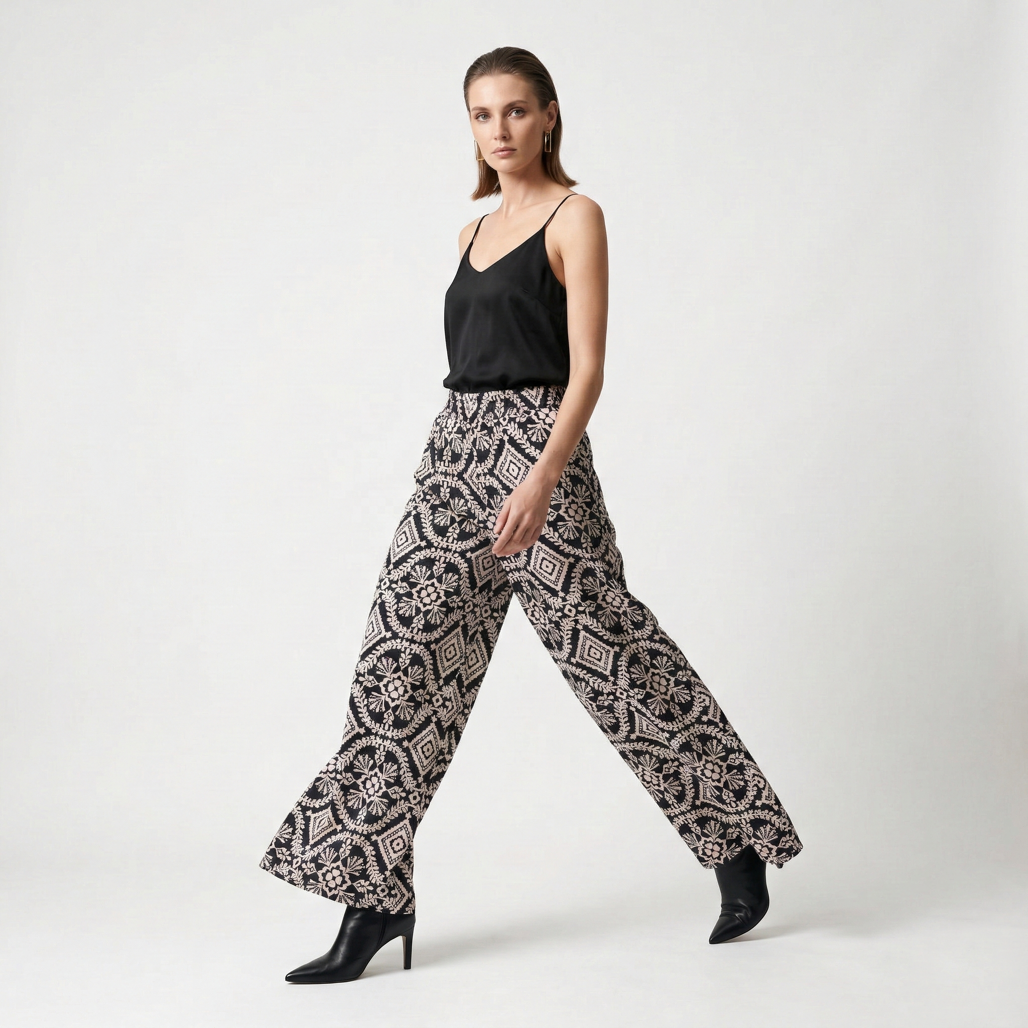 Elegant dark high-waisted wide-leg trousers with an intricate geometric and floral embroidery pattern