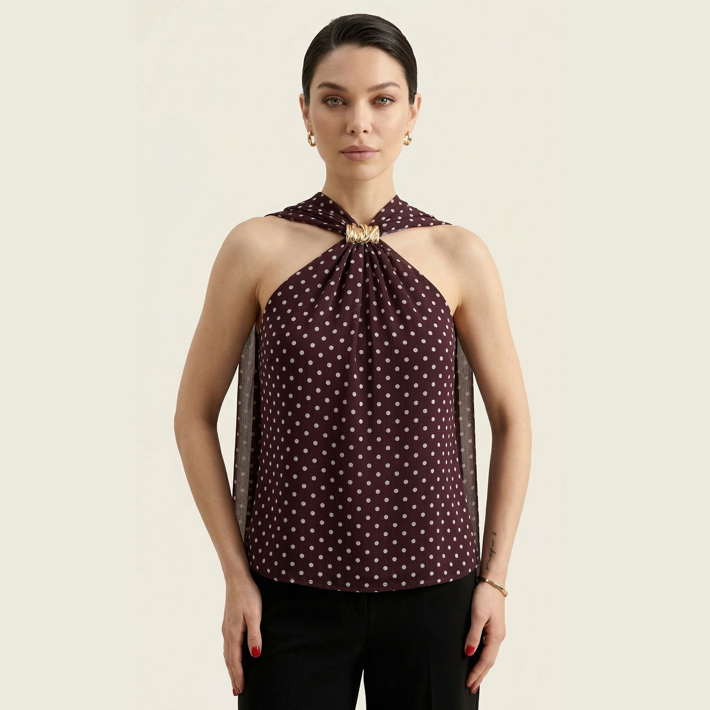 Brown polka dot blouse with a gathered neckline and flowing sleeves.